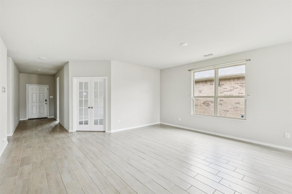 969 Ravenwood Lane Van Alstyne, TX 75495 - Photo 4 of 27 an empty room with wooden floor and windows