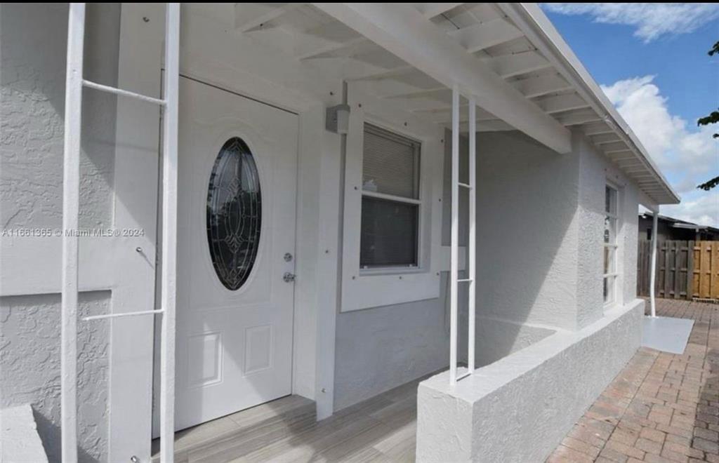 a view of a hallway with wooden floor and entryway