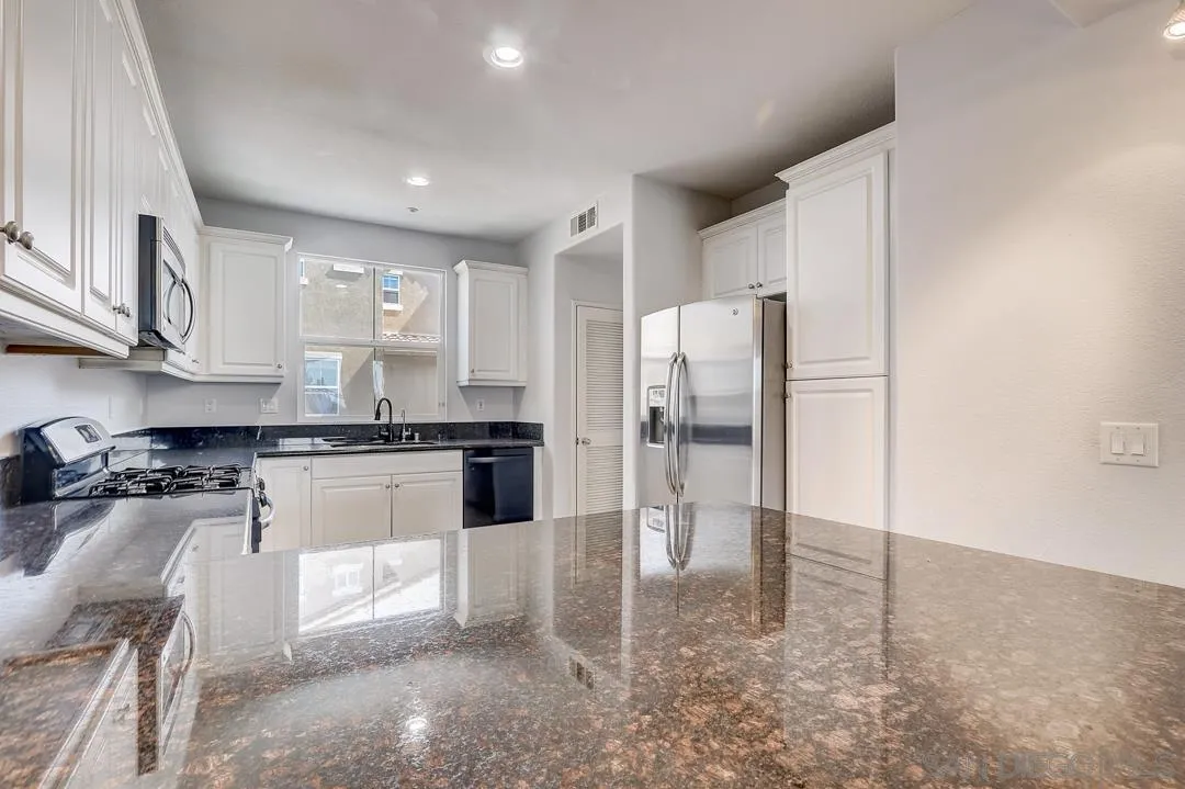 10225 Daybreak Lane, Unit 2 Santee, CA 92071 - Photo 9 of 20 a kitchen with stainless steel appliances granite countertop a refrigerator and a stove top oven