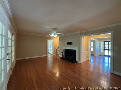 1513 Raeford Road Fayetteville, NC 28305 - Photo 10 of 25 an empty room with wooden floor fireplace and windows