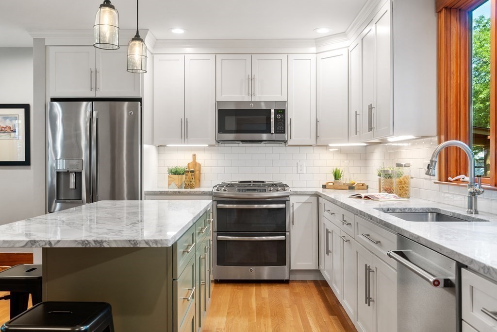 98 Hillside Avenue Arlington, MA 02476 - Photo 11 of 36 a kitchen with kitchen island granite countertop a sink stainless steel appliances and cabinets