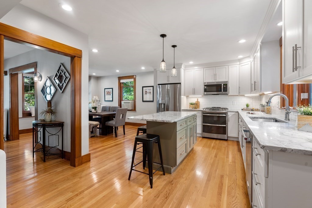 98 Hillside Avenue Arlington, MA 02476 - Photo 12 of 36 a kitchen with kitchen island granite countertop a sink counter top space appliances and cabinets
