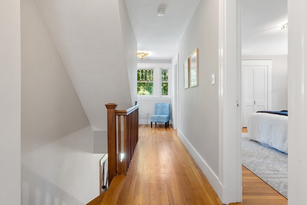 98 Hillside Avenue Arlington, MA 02476 - Photo 27 of 36 a view of a hallway with wooden floor and furniture