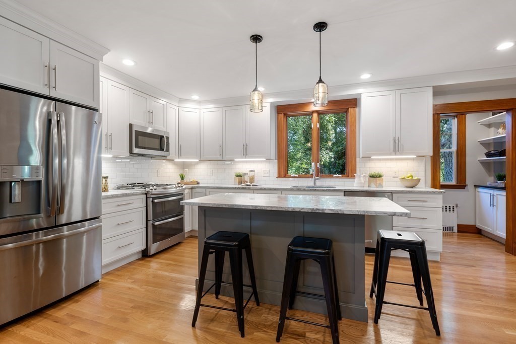 98 Hillside Avenue Arlington, MA 02476 - Photo 10 of 36 a kitchen with granite countertop wooden floors appliances and furniture