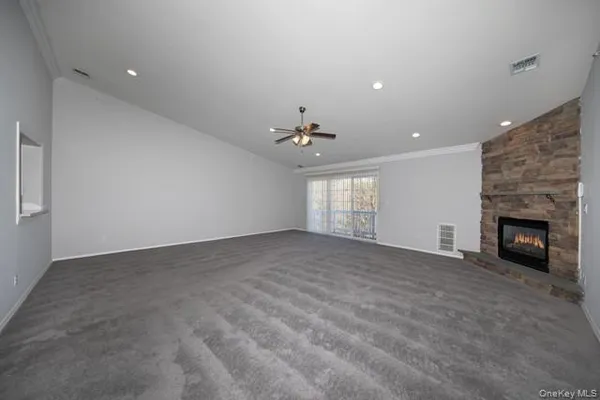 a view of an empty room with a fireplace and a window