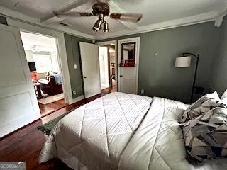 a bedroom with a bed and wooden floor