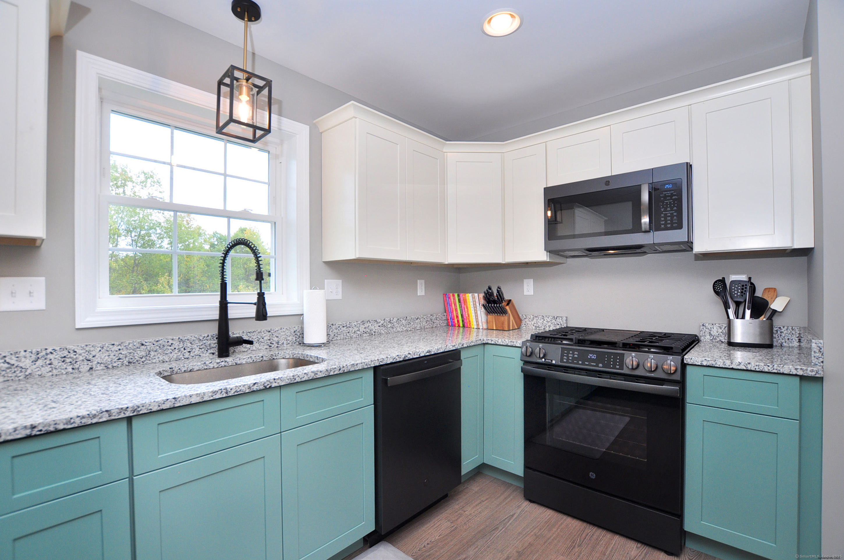 34 West River Road East Windsor, CT 06088 - Photo 16 of 31 a kitchen with granite countertop a sink a stove a microwave and wooden cabinets