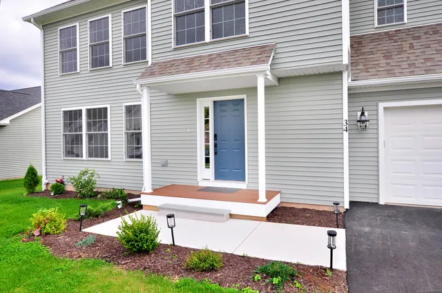 a view of a house with brick walls and a yard with plants