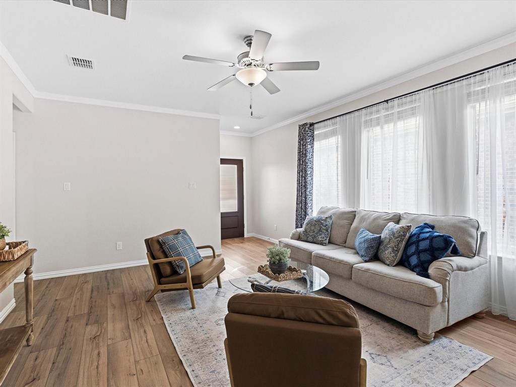 16936 Post Cedar Drive Justin, TX 76247 - Photo 4 of 30 Spacious living area featuring wood-finish flooring, crisp white walls, and crown molding