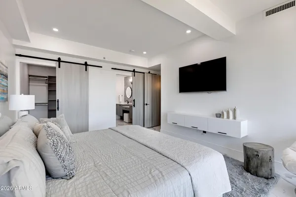 a bedroom with a large bed and a flat screen tv