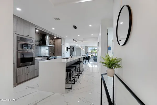 a kitchen with stainless steel appliances kitchen island granite countertop a stove a sink a microwave and a refrigerator
