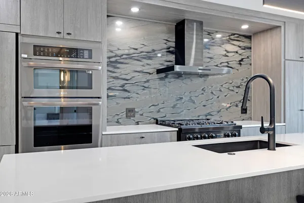 a kitchen with stainless steel appliances a stove and a refrigerator with white cabinets