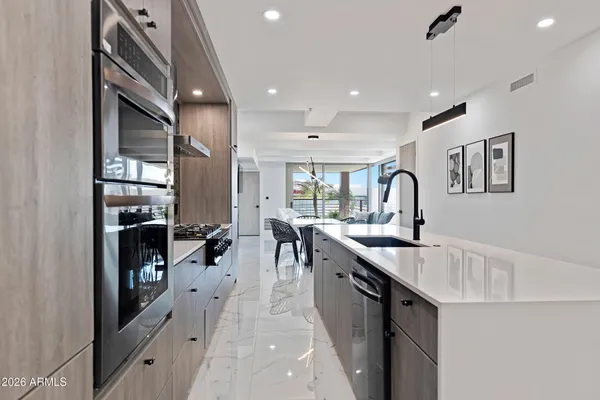a kitchen with stainless steel appliances granite countertop a sink and a refrigerator
