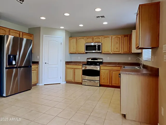 a kitchen with stainless steel appliances granite countertop a stove a sink and a refrigerator