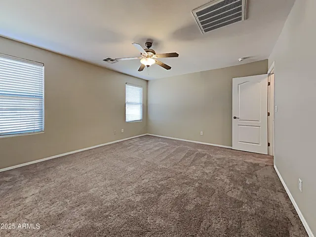 a view of an empty room with a chandelier fan