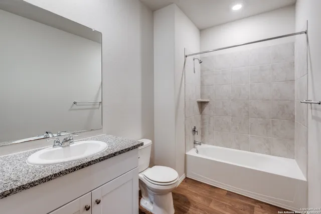 a bathroom with a granite countertop sink toilet and shower