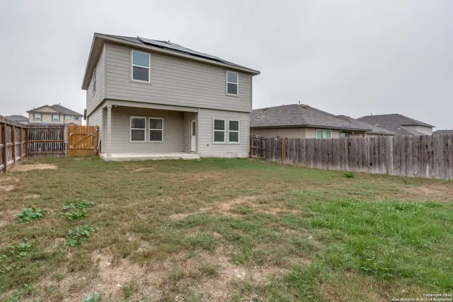 a front view of a house with yard and tree