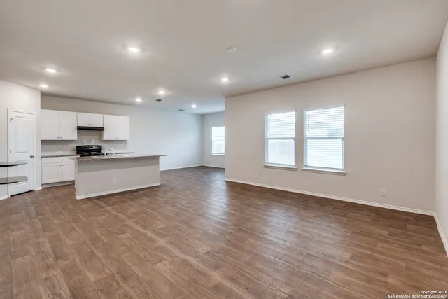 a view of kitchen with stove and cabinets