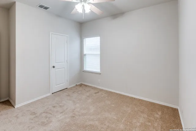 an empty room with a chandelier fan