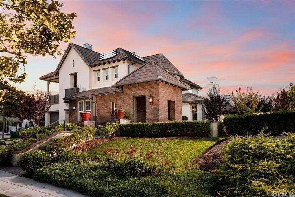 a front view of a house with a yard and potted plants