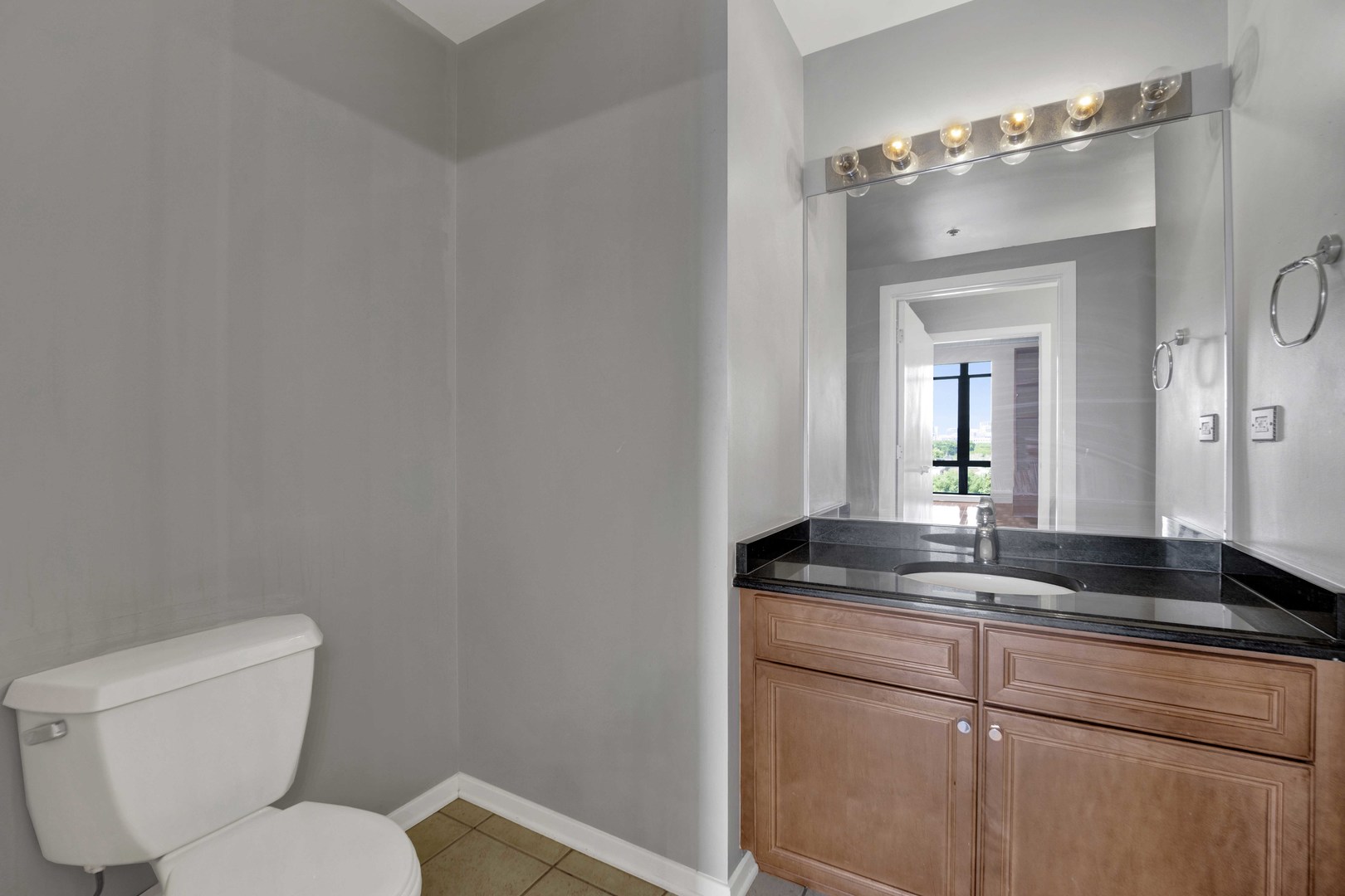 1525 South Sangamon Street, Unit 504 Chicago, IL 60608 - Photo 22 of 32 a bathroom with a granite countertop sink and a mirror