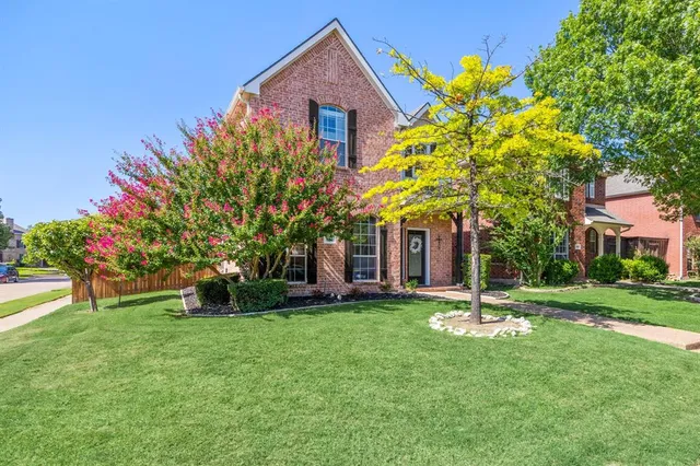 a front view of a house with a yard and tree