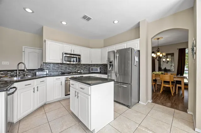 a kitchen with stainless steel appliances granite countertop a refrigerator and a sink