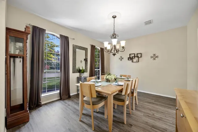 a view of a dining room with furniture a chandelier and wooden floor