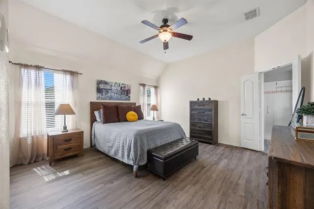 a bedroom with a bed a ceiling fan and a bookshelf