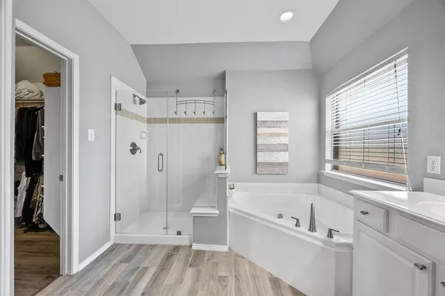 a bathroom with a tub shower and sink