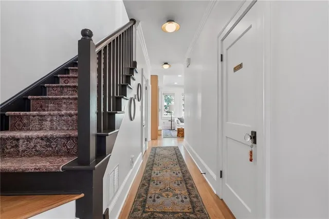 a view of a hallway with wooden floor and staircase