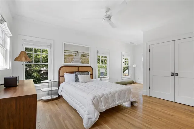 a bedroom with a large bed and windows