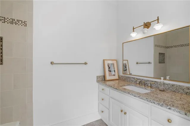 a bathroom with a granite countertop sink and a mirror