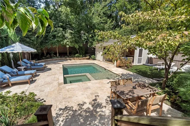 a view of a swimming pool with lawn chairs under an umbrella