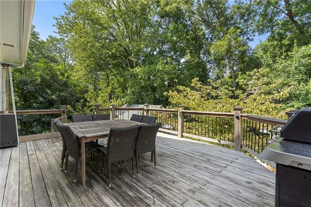 a balcony with wooden floor table and chairs