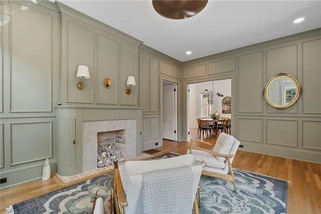 a living room with furniture a clock and a fireplace