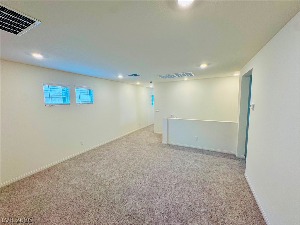 9249 Innot Avenue Las Vegas, NV 89148 - Photo 10 of 24 A versatile upstairs loft with plush carpeting provides ample space for relaxation and activity.