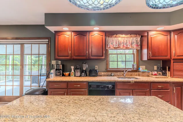 a kitchen with stainless steel appliances granite countertop a refrigerator and a stove