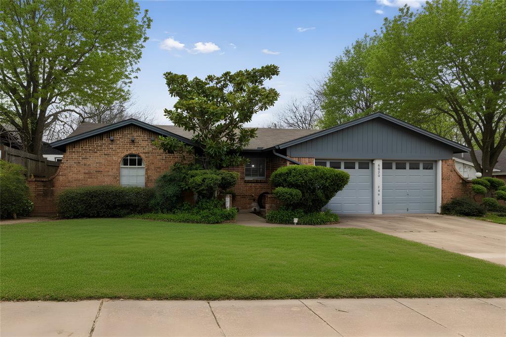 6020 Harrison Way Watauga, TX 76148 - Photo 1 of 32 Ranch-style home with brick siding, a front yard, driveway, and a garage