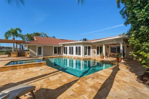 a view of swimming pool with lawn chairs and potted plants