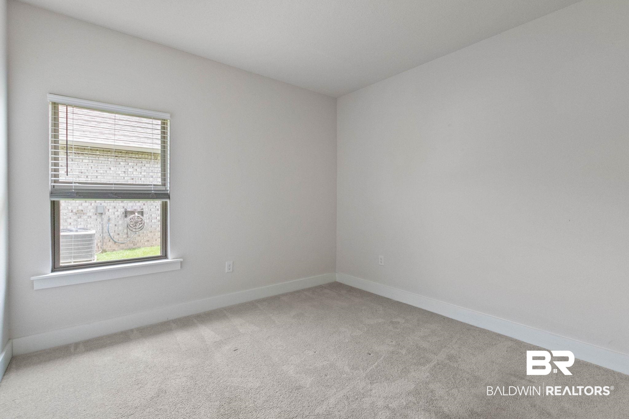 1710 Grouse Street Foley, AL 36535 - Photo 49 of 76 Light-filled room featuring neutral wall paint, gray carpet, white trim, and a window with horizontal blinds