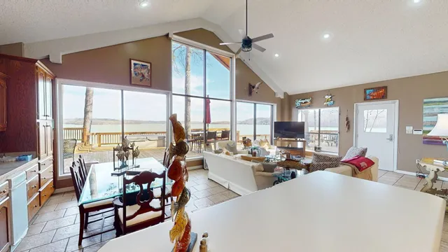 a living room with furniture kitchen view and a large window