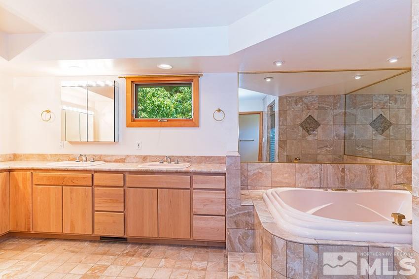 375 Chevy Chase Street Reno, NV 89509 - Photo 15 of 25 a bathroom with a tub sink and mirror