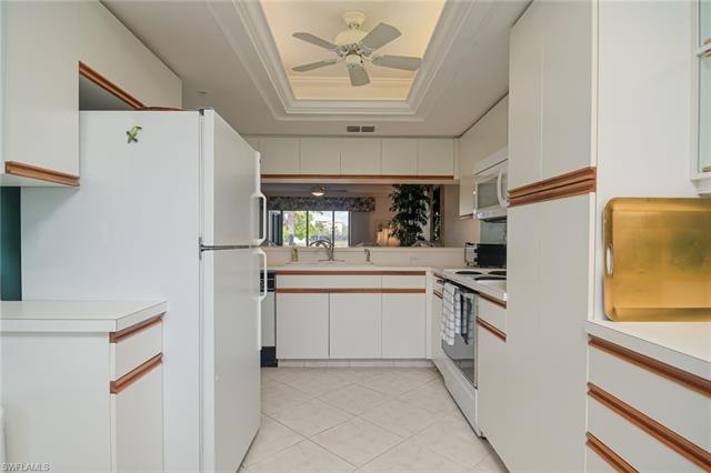 4120 Lorene Drive, Unit 101 Estero, FL 33928 - Photo 11 of 45 a kitchen with white cabinets and white appliances