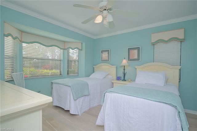4120 Lorene Drive, Unit 101 Estero, FL 33928 - Photo 20 of 45 a bedroom with two beds and a chandelier