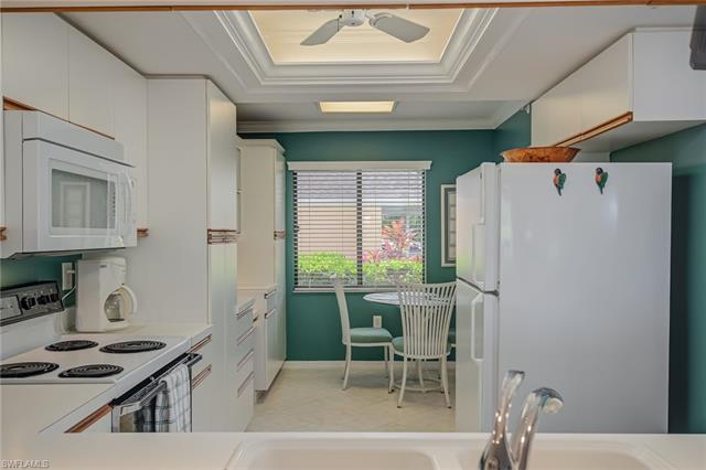 4120 Lorene Drive, Unit 101 Estero, FL 33928 - Photo 9 of 45 a kitchen with stainless steel appliances granite countertop a refrigerator and a stove