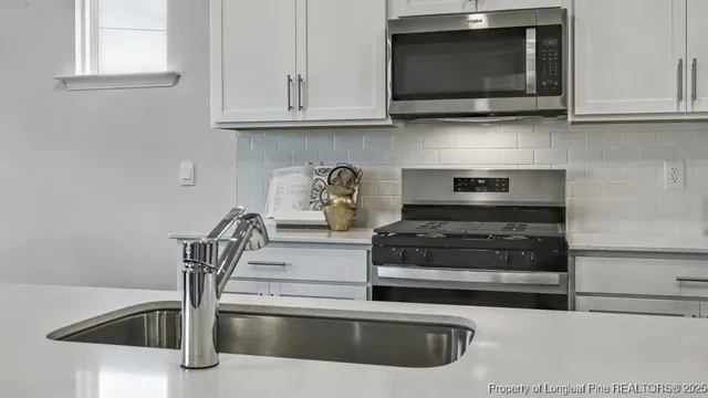 a kitchen with stainless steel appliances granite countertop a stove and a microwave