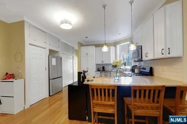 a kitchen with a dining table chairs refrigerator and cabinets