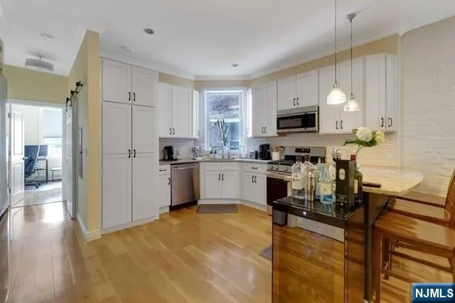 a kitchen with a refrigerator cabinets and wooden floor