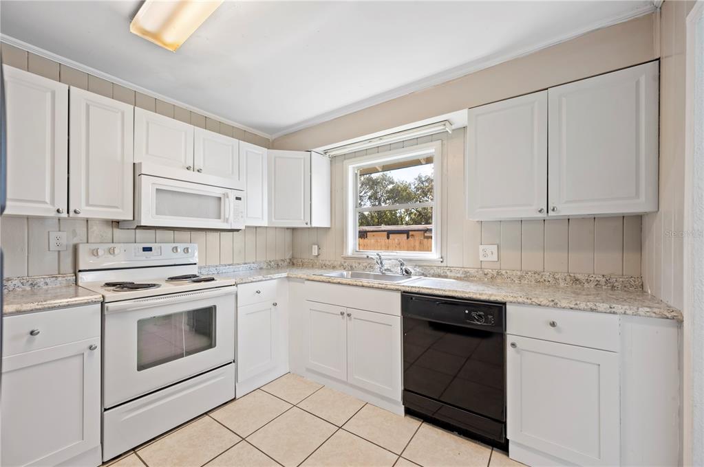 3221 Crutchfield Road Lakeland, FL 33805 - Photo 20 of 49 a kitchen with white cabinets appliances a sink and a window